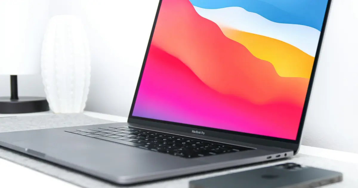 black laptop computer turned on near white sofa